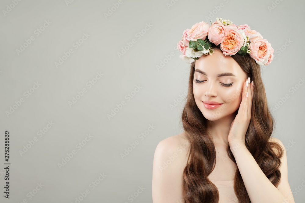 Naklejka premium Portrait of beautiful healthy woman with clear skin, curly hair and rose flowers wreath