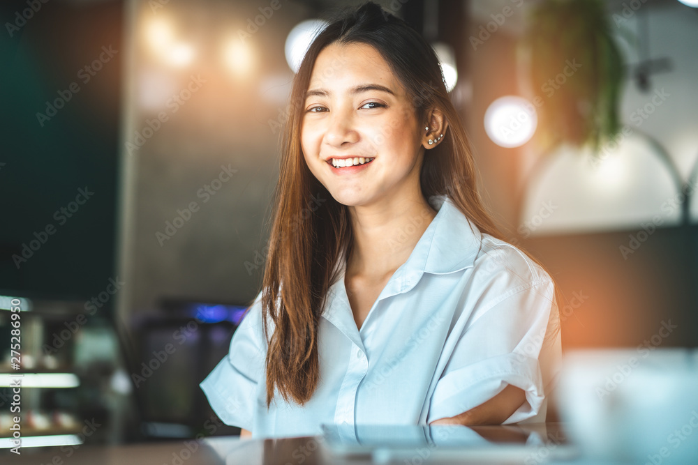 Asian woman in a cafe drinking coffee .Portrait of Asian woman smiling in coffee shop cafe vintage colour tone. Asian woman in a cafe drinking coffee .Portrait of Asian woman smiling in coffee shop cafe vintage colour tone.