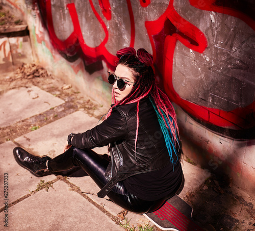 Photography Beautiful young girl with colored dreads sitting in the sun