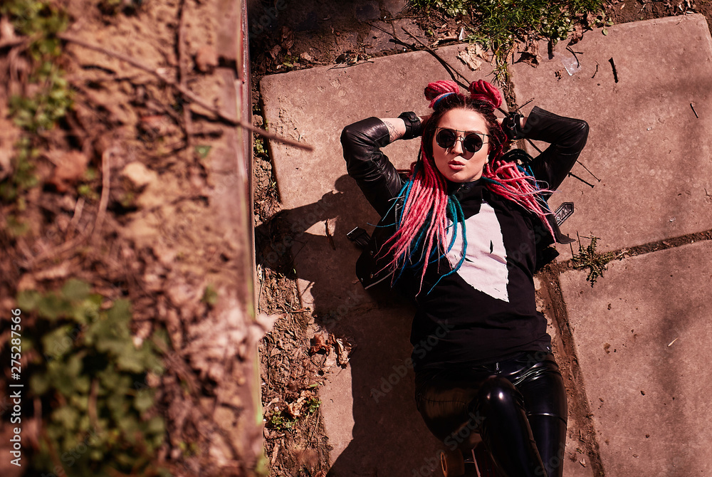 Naklejka premium Stylish girl lies in the sun and photographed
