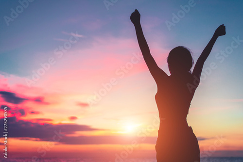 Happy woman standing arms outstretched back and enjoy life on the beach at Sea