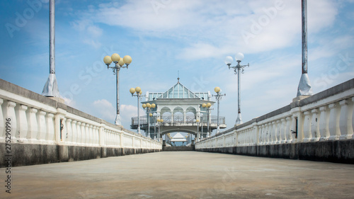 Low angle shot of walkway over old Sarasin pedestrian bridge to its tower. Street lamps in both sides. Phuket, Thailand