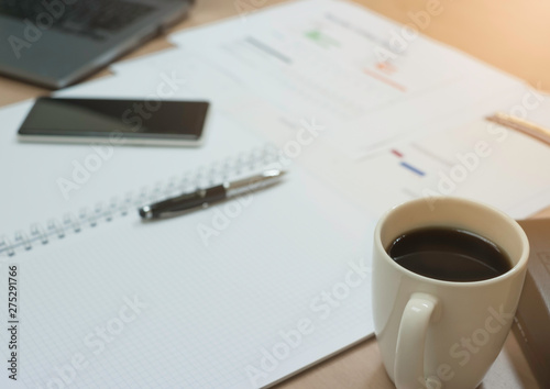 Business Document Report, Laptop, Pen , Smartphone And white Coffee Cup on desk.