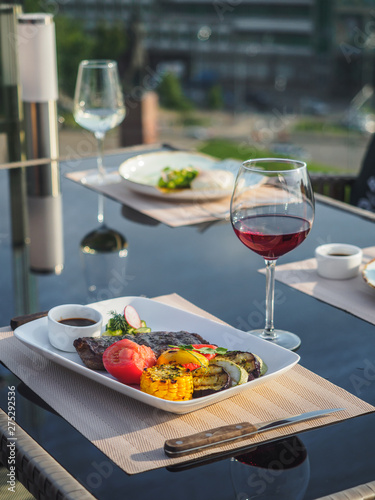 Beef steak with grilled vegetables. Dish and glass of red wine