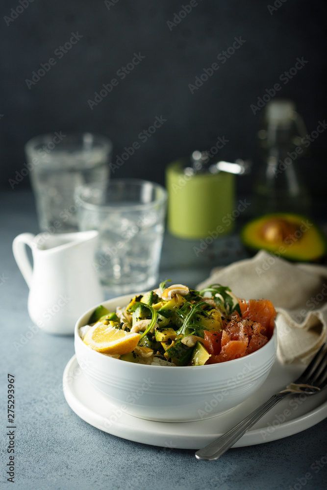 Healthy rice bowl with avocado, salmon and cashew nuts Healthy rice bowl with avocado, salmon and cashew nuts