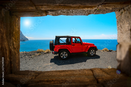 Stone window and red summer car. Free space for your decoration and sunny day. 