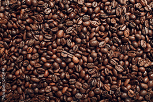 Roasted coffee beans brown seeds texture background wallpaper. Top view.