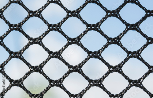 Macro photograph of a black nylon mesh fabric. Details, textures and backgrounds