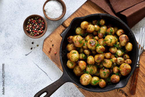 Fried, young potatoes with spices in a pan. View from above. photo