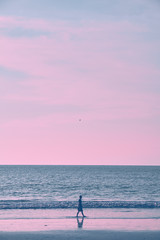 Papier peint photo Pourpre Girl on the beach during sunset  © badahos