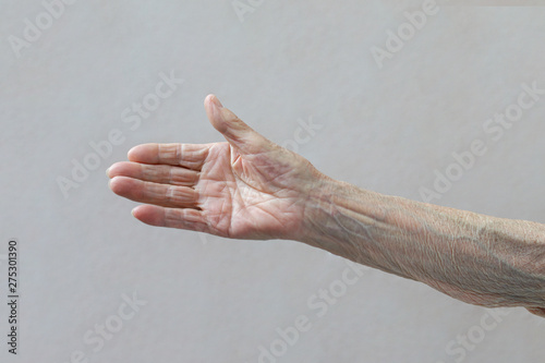 Old lady's hand. Elderly lady is waiting for help. Elderly concept with light background.