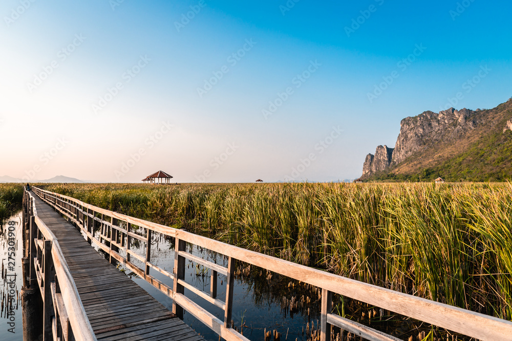 Obraz premium Wooden Bridge in the lake and mountain lanscape on sunset at Khao Sam Roi Yot National Park, Thailand.