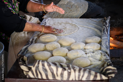 Close up of old Arab woman hands kneading fresh dough for Taboon bread or Lafah is a Middle Eastern flatbread also called lafa or Iraqi pita. photo