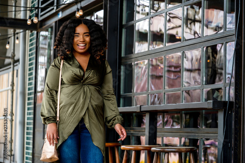 Portrait of woman laughing next to outdoor seating