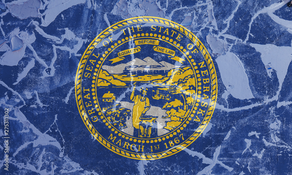 The national flag of the US state Nebraska in against a gray wall with cracks and faults on the day of independence in colors of blue and yellow. Political and religious disputes, customs and delivery