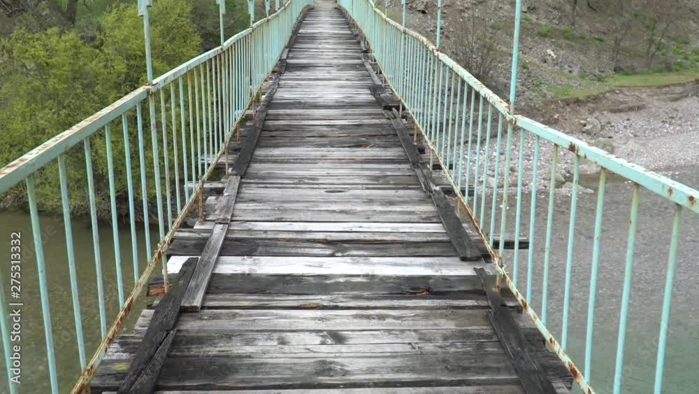 Walking on a old and dangerous suspended bridge Walking on a old and dangerous suspended bridge