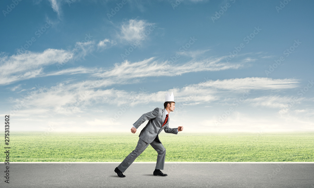 King businessman in elegant suit running and blue sky at background King businessman in elegant suit running and blue sky at background