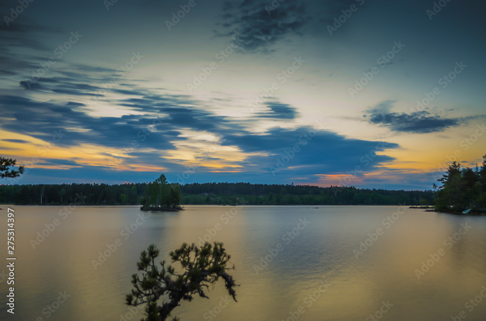 Peaceful movement of blue cloud on a countryside lake during the sunset through the orange horizon in beatiful day