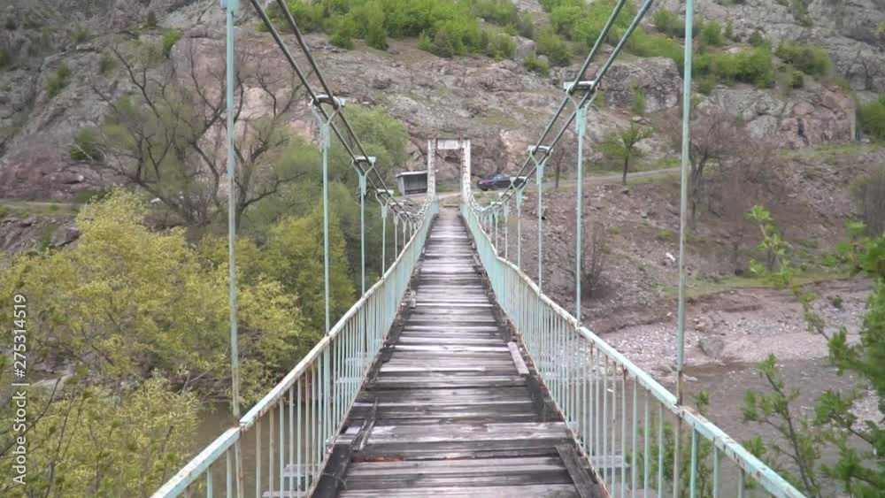 Walking on a old and dangerous suspended bridge Walking on a old and dangerous suspended bridge