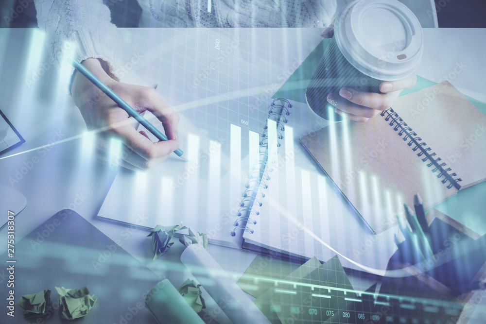 Financial forex graph displayed on hands taking notes background. Concept of research. Multi exposure Financial forex graph displayed on hands taking notes background. Concept of research. Multi exposure