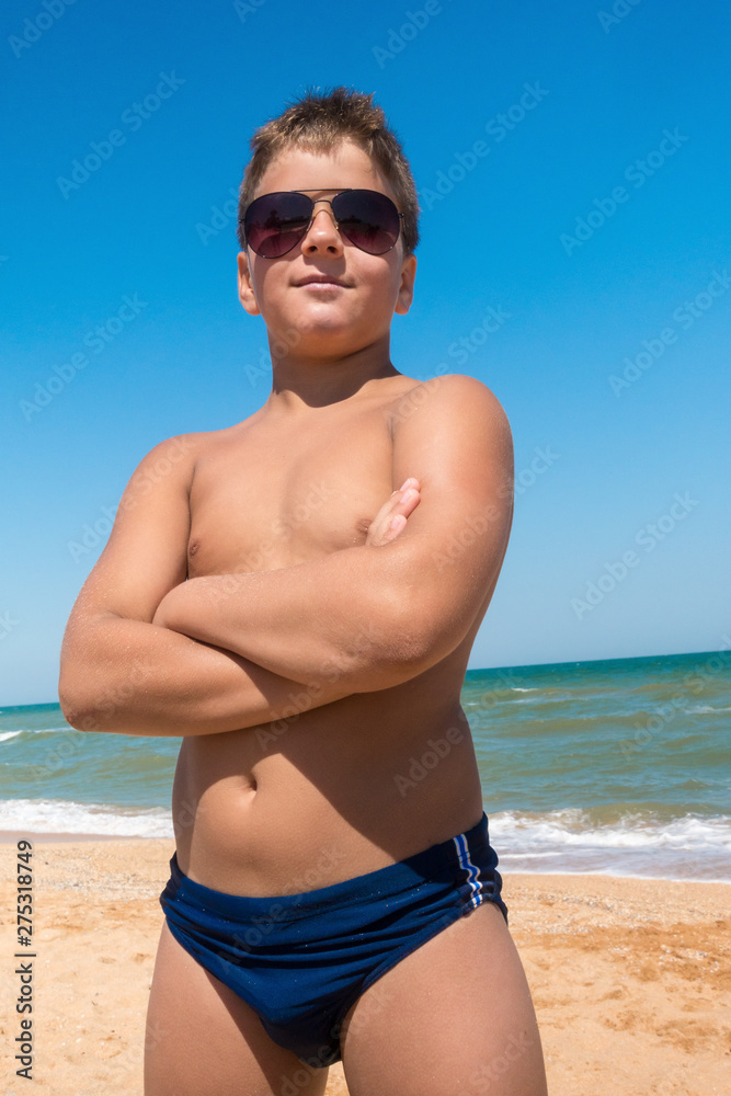 Young boy standing on the beach, outdoors Young boy standing on the beach, outdoors