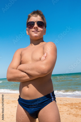 Young boy standing on the beach, outdoors