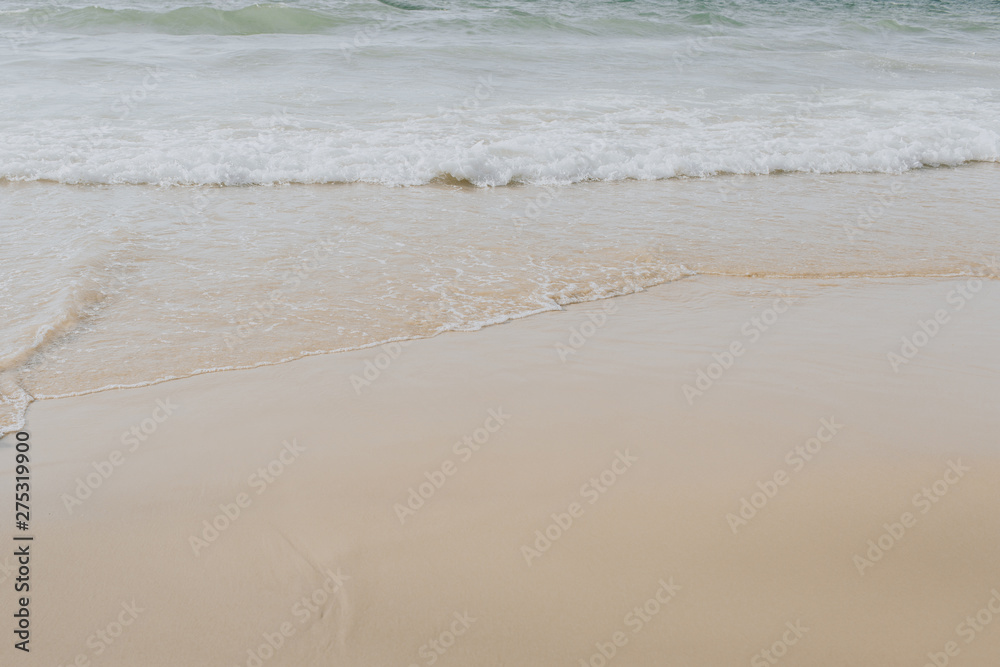 Beautiful tropical beach view with white beige sand and  sea with waves on Phuket, Thailand. Minimal composition with neutral colors. Summer concept. Natural background.