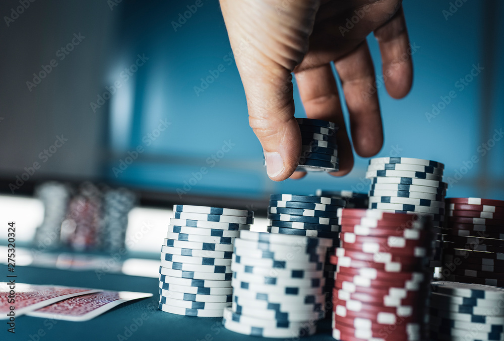 Lucky player stacking poker chips at casino