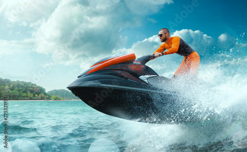 Young Man on water scooter, Tropical Ocean, Vacation Concept. Jet Ski. Sea. photo