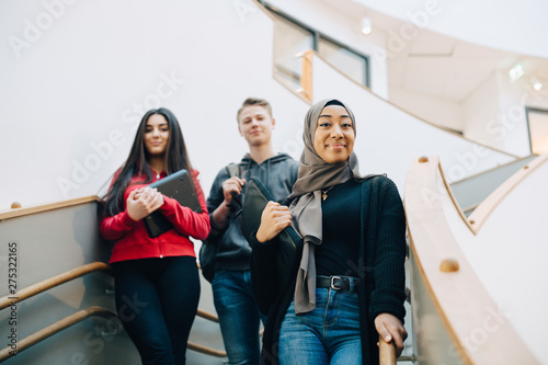 Canvas Print Portrait of teenage friends standing on steps at high school