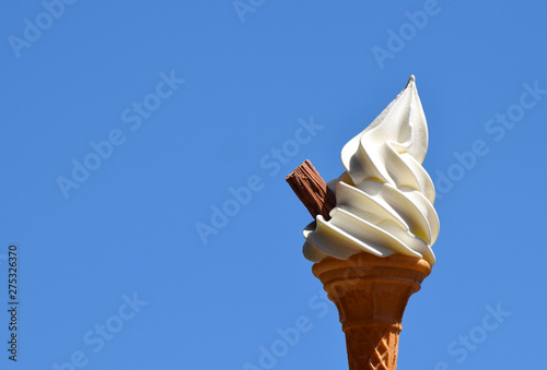 Soft whipped vanilla ice cream in a wafer cone with a chocolate flake photo