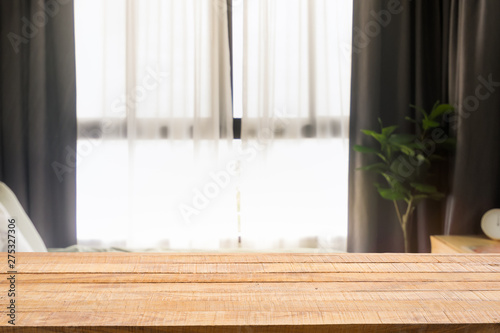 Wooden table on Defocused bedroom and curtain window with sunlight in the early morning. For montage product display or design key visual layout