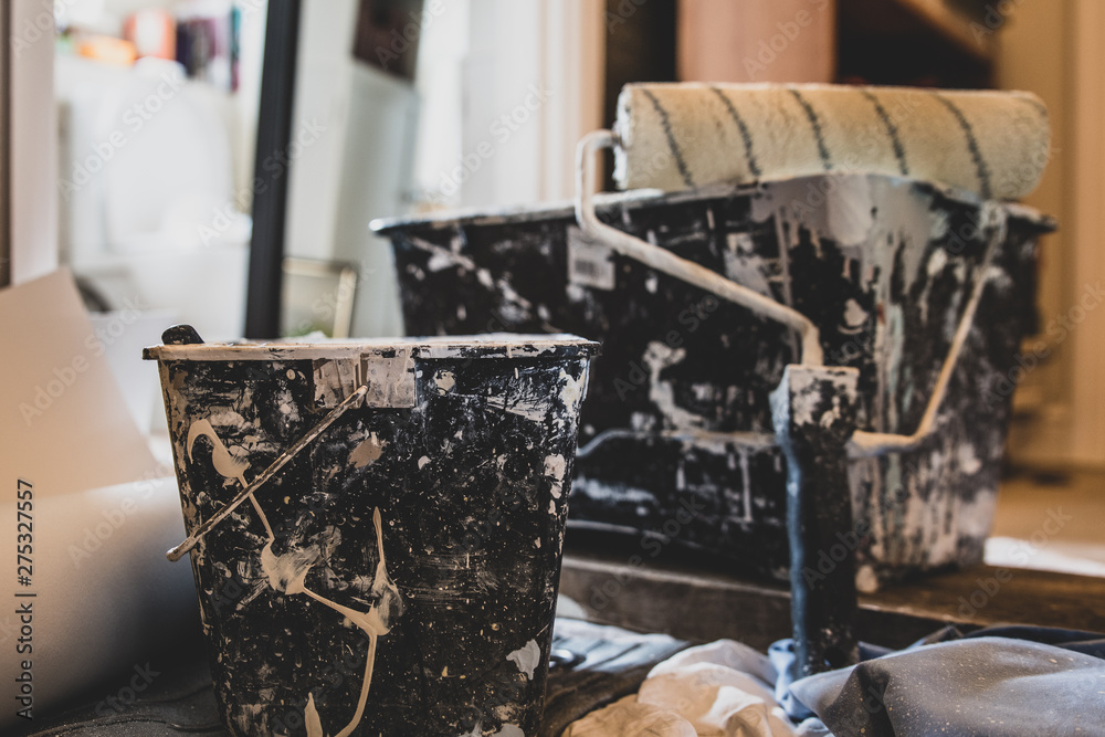 Buckets of paint with paint brush and roller brush - house being decorated or renovated. Also DIY theme. Buckets of paint with paint brush and roller brush - house being decorated or renovated. Also DIY theme.