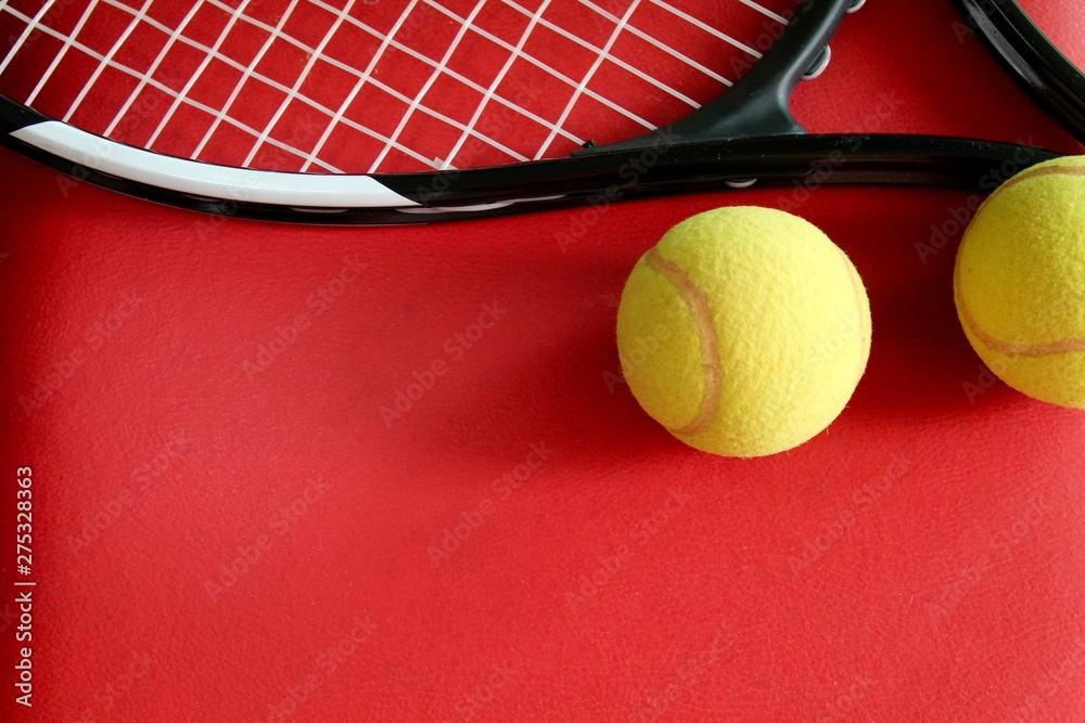Raquete e bolas de tênis no fundo vermelho