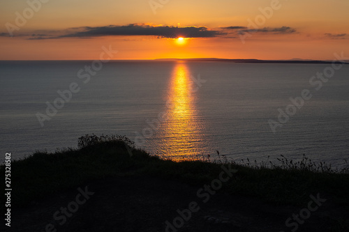 Stunning golden sunset from the Cliffs of Moher looking out towards the island of Inisheer, Ireland