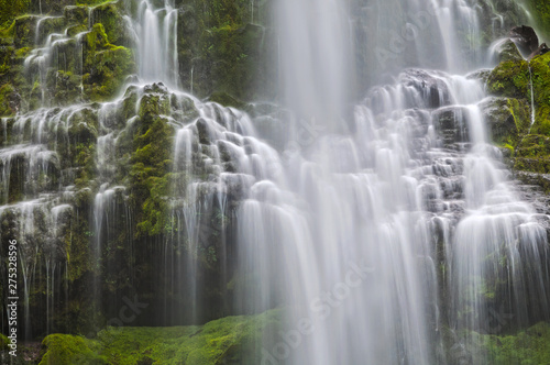 Cascading waterfall with rows of spilled water and green mossy rocks