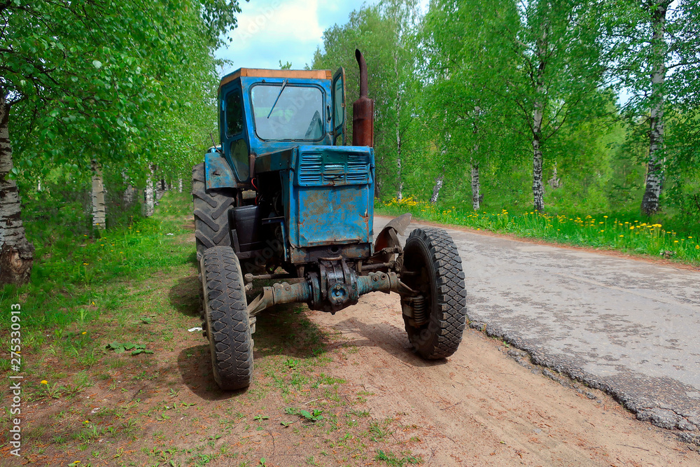 old rusty farm tractor parked on the side of a country road old rusty farm tractor parked on the side of a country road