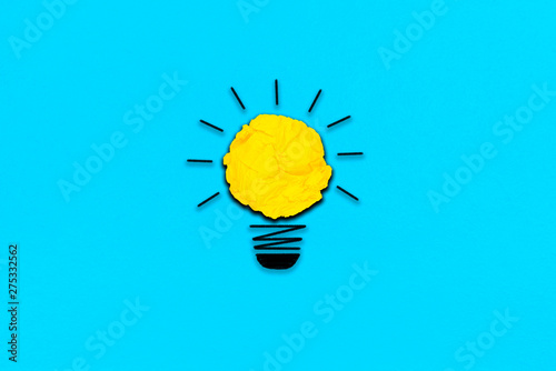 creative inspiration from yellow concept crumpled paper turn on light bulb metaphor for good idea concept on light blue paper  background / best solution think answer