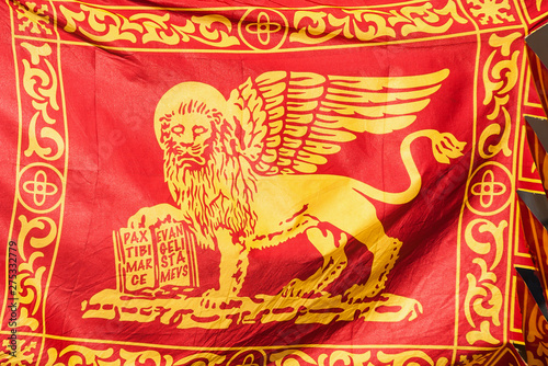 Old Venice Republic Flag with Saint Mark Lion and motto 'Pax tibi Marce, evangelista meus' (Peace be with thee, O Mark, my evangelist) fluttering in the wind as background photo