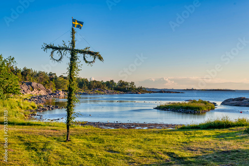 Photo Sunrise of a classic midsommer pole at the coast line of Roslagen
