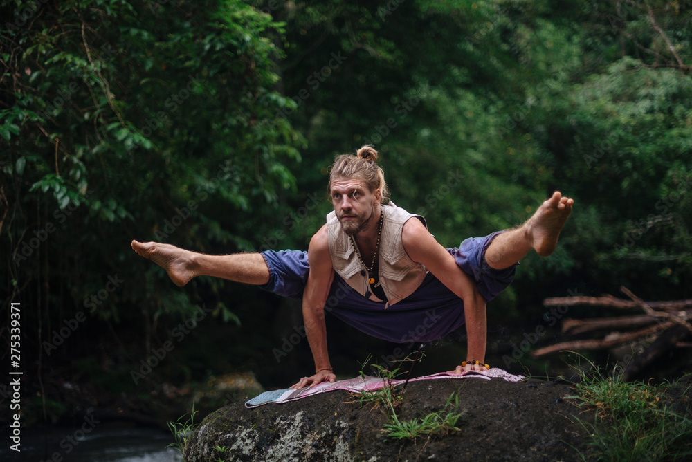 Yoga practice and meditation in nature. Man practicing near river Yoga practice and meditation in nature. Man practicing near river