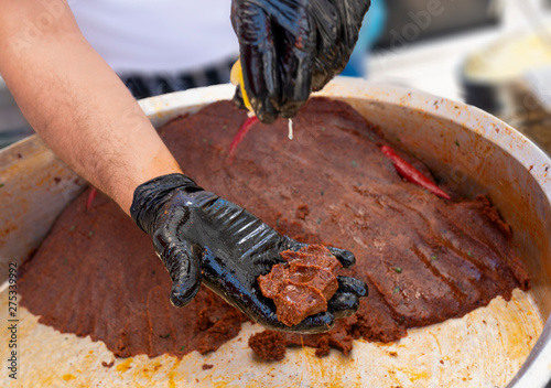 Man is kneading raw meat (cig kofte) with traditional method. photo