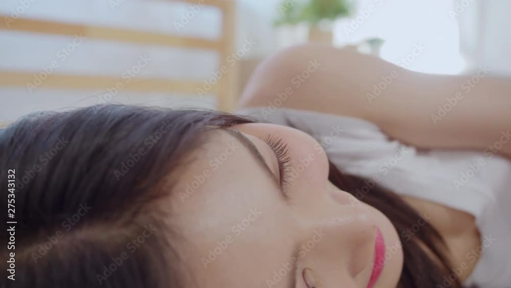 Young Asian woman using smartphone checking social media feeling happy smiling while lying on bed after wake up in the morning, Beautiful attractive Japanese girl smiling relax in bedroom at home. Young Asian woman using smartphone checking social media feeling happy smiling while lying on bed after wake up in the morning, Beautiful attractive Japanese girl smiling relax in bedroom at home.