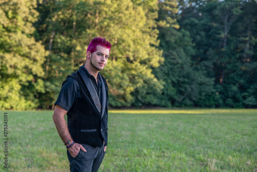 Alternative diverse male - black clothes, pink hair smirking at camera. Alternative diverse male - black clothes, pink hair smirking at camera.