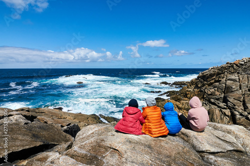 Four people staring at the sea at the Coast od Death, Laxe, Spain