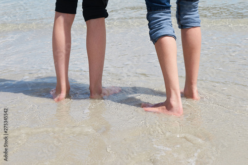 Feet of 2 kids at the sea shore