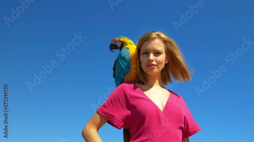 Macaw Parrot on Blonde Model�s Shoulder With Clear Blue Skies in the Background