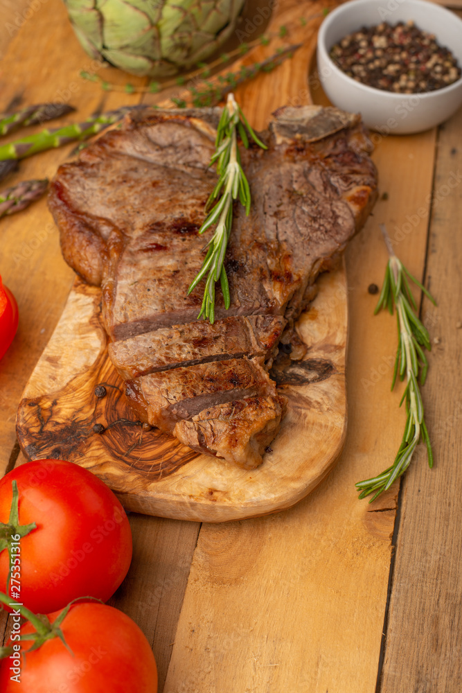 Asparagus, and the artichoke and sprig of tomatoes and sweet red pepper and Italian spaghetti on a cutting board with a knife, sliced. 