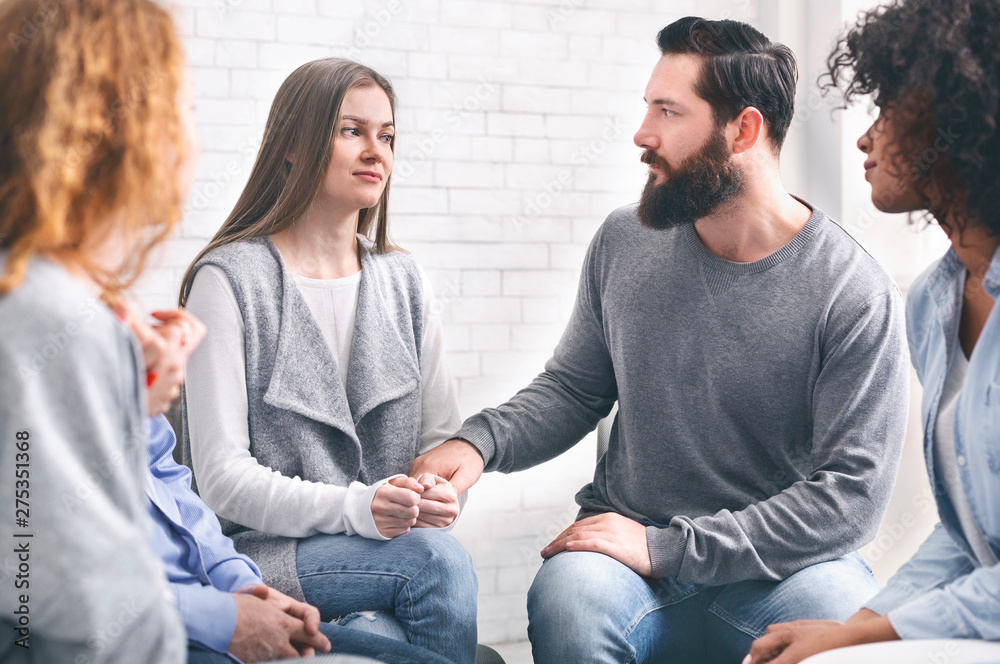 Depressed addicted woman sharing her problems at group meeting Depressed addicted woman sharing her problems at group meeting