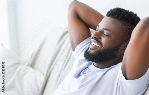Happy african man enjoying weekend, relaxing at home